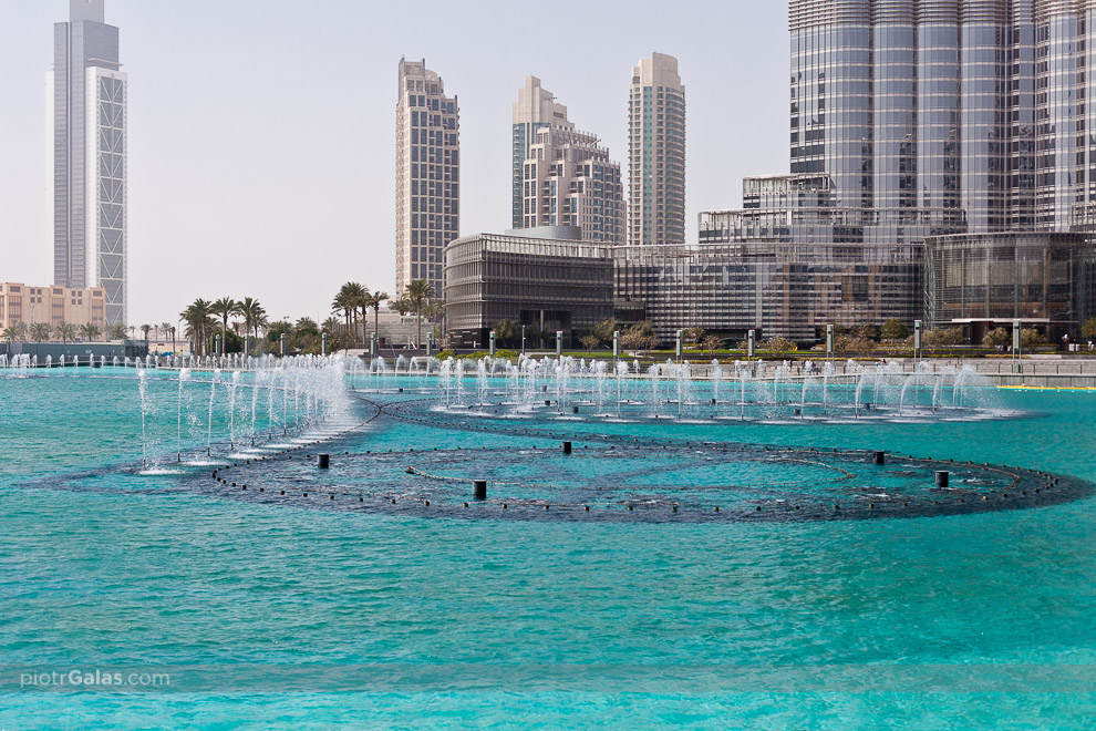 Dubaj 2013 // Przed Burj Khalifa oraz Dubai Mall znajduje się gigantyczny zbiornik wodny, w którym zainstalowany jest system zasilający gigantyczną fontannę. W określonych porach dnia (2 razy w okolicach południa), ale w szczególności wieczorem (co pół godziny), organizowane są pokazy światła, muzyki i wody. Woda potrafi wystrzeliwać nawet na 150 metrów w górę, co odpowiada budynkowi i wysokości 50-ciu pięter, a światła bywają widoczne nawet z odległości 20 mil. Każdy pokaz gromadzi tysiące gapiów, w szczególności turystów przebywających w okolicy.